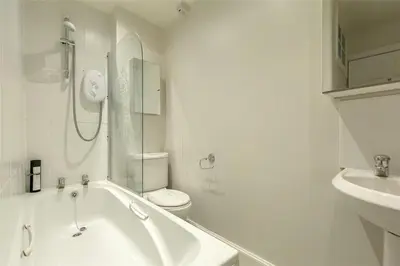 a bathroom with a tub and a toilet and a sink at New Town Cottage in Edinburgh