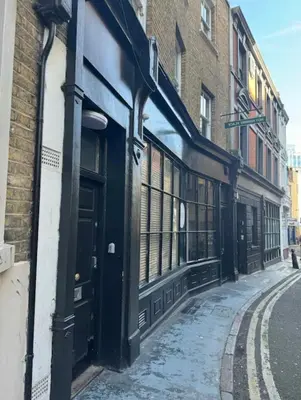 an empty street in an alley with buildings at Apartment in the heart of London in Moffat