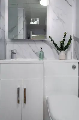 a white bathroom with a sink and a mirror at Modern Comfort in Historic Callander in Stirling
