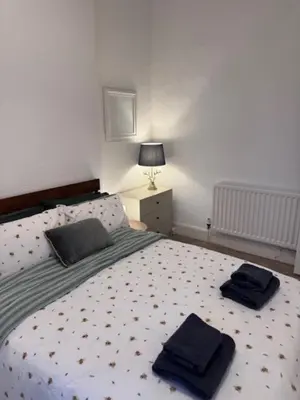 a bedroom with a bed with two towels on it at Balloch But & Ben in Balloch