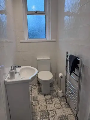 a bathroom with a toilet and a sink and a window at Balloch But & Ben in Balloch