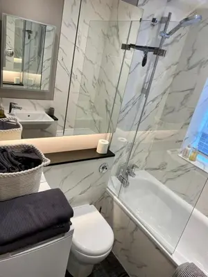 a white bathroom with a toilet and a sink at Elegant Chelsea Apartment in Moffat