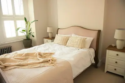 a bed with white sheets and pillows in a bedroom at Wimbledon Tennis House in Moffat