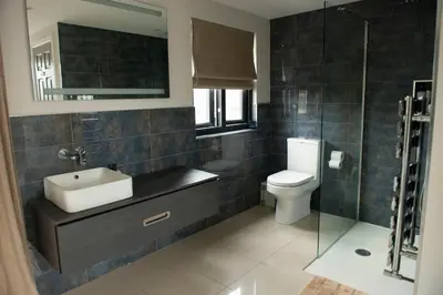 a bathroom with a sink and a toilet and a mirror at Wimbledon Tennis House in Moffat