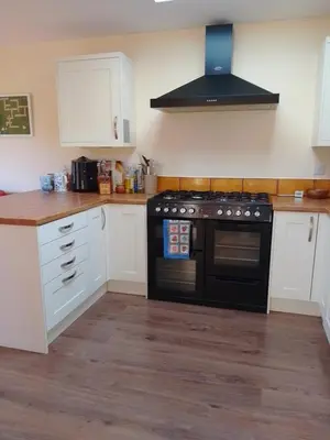 a kitchen with a black stove and white cabinets at Comfortable room with en suite in Edinburgh