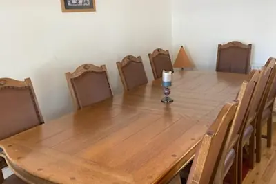 a wooden table with chairs and a candle on top at Argyll Farmhouse-Idyllic Setting-Sleeps10 in Dunoon