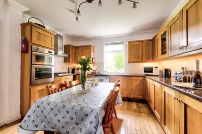 a kitchen with a table with a vase on it at Argyll Farmhouse-Idyllic Setting-Sleeps10 in Dunoon