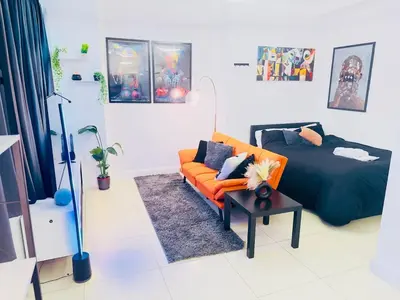 a bedroom with a bed and a orange couch at Smart Artistic studio in shoreditch in Moffat