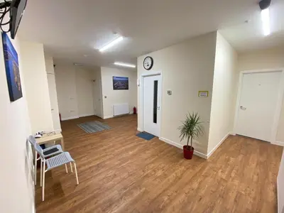 an empty room with a clock on the wall at Whitefield Guesthouse in Glasgow