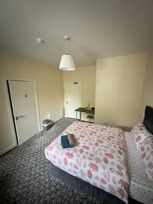 a bedroom with a bed with a book on it at Whitefield Guesthouse in Glasgow