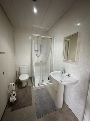 a bathroom with a shower and a sink and a toilet at Whitefield Guesthouse in Glasgow
