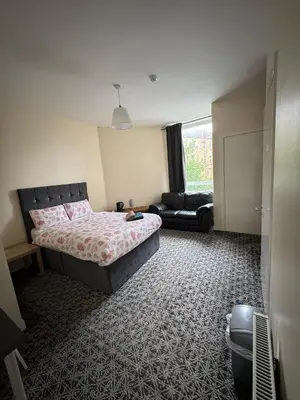 a bedroom with a bed and a couch in it at Whitefield Guesthouse in Glasgow