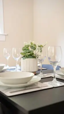 a table with wine glasses and a potted plant on it at Graham House in Livingston