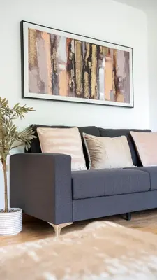 a blue couch in a living room with a painting at 4 BDR House By Caledonia Luxe Stays Short Lets & Serviced Accommodation Livingston in Livingston