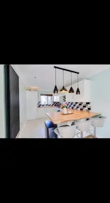 a kitchen with a large wooden table and chairs at Modern home Close to all Cardiff venues in Moffat