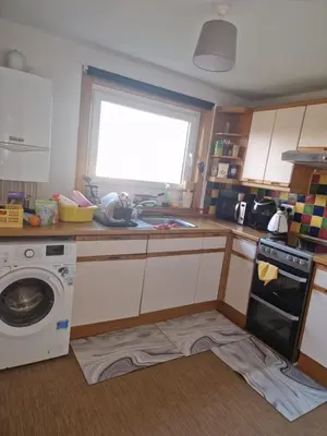 a kitchen with a sink and a washing machine at Vibrant Room in Centeral Ayr in Ayr