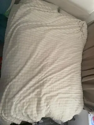 a white blanket laying on top of a bed at Gravesend one room apartment in Moffat