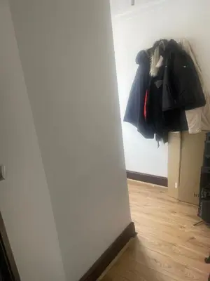a room with a white wall and a pile of clothes at Gravesend one room apartment in Moffat