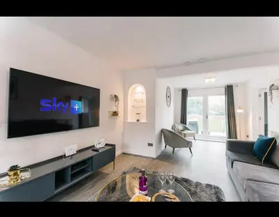 a living room with a large flat screen tv on a wall at Asentral Homes in Moffat