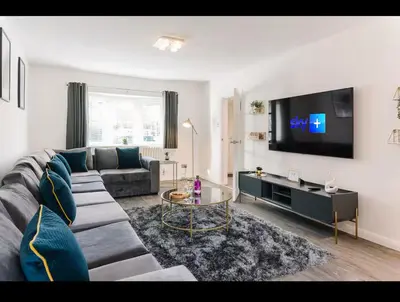 a living room with a couch and a flat screen tv at Asentral Homes in Moffat