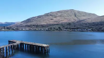 a dock in the middle of a lake with a mountain at No4 Invereoch in Arrochar