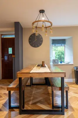 a dining room table with a large clock on the wall at No4 Invereoch in Arrochar