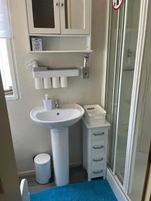 a small bathroom with a sink and a shower at Static Caravan in Moffat