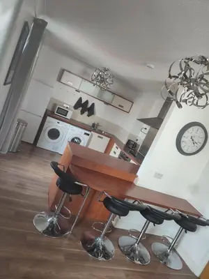 a kitchen with a table and two bar stools at Rosebank Apartment Edinburgh City in Edinburgh