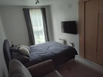 a bedroom with a bed and a tv and a couch at Rosebank Apartment Edinburgh City in Edinburgh