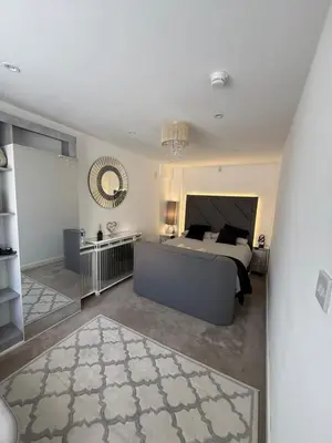 a large bedroom with a bed and a mirror at Edinburgh city break room in Edinburgh