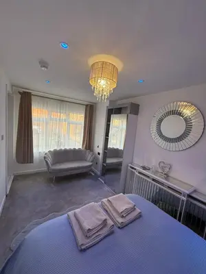 a bedroom with a bed and a mirror and a couch at Edinburgh city break room in Edinburgh