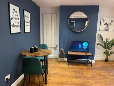 a living room with a table and a mirror at First Avenue Apartments in Moffat