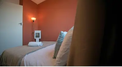 a bedroom with a bed and a red wall at 3 bedroom cosy apartment 20 mins to Centre in Moffat