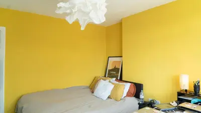 a bedroom with a bed and a yellow wall at 3 bedroom cosy apartment 20 mins to Centre in Moffat