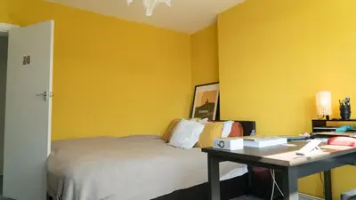 a bedroom with yellow walls and a bed with a desk at 3 bedroom cosy apartment 20 mins to Centre in Moffat