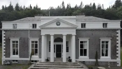an old brick house with white columns at Craigielands House in Beattock