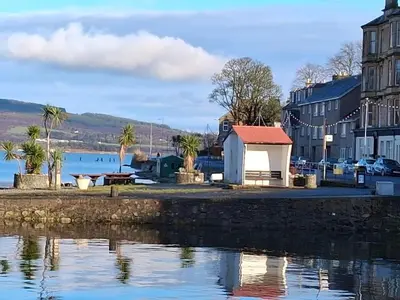 a small white building next to a body of water at The Port in Port Bannatyne