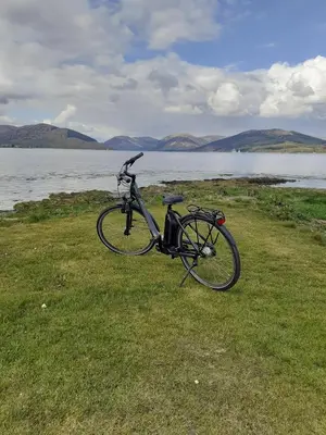a bike parked on the grass near a body of water at The Port in Port Bannatyne