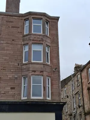 a brick building with five windows on the side of it at The Port in Port Bannatyne