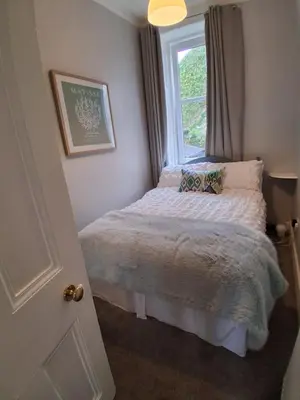 a small bedroom with a bed with a window at The Port in Port Bannatyne