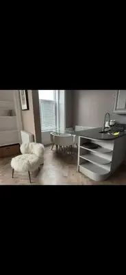 a living room with a desk and a table at Largs Sandringham Apartment in Largs