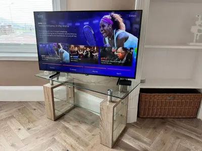 a flat screen tv sitting on a glass stand at Largs Sandringham Apartment in Largs