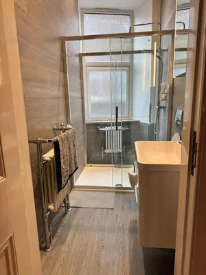 a bathroom with a shower and a sink and a toilet at Largs Sandringham Apartment in Largs