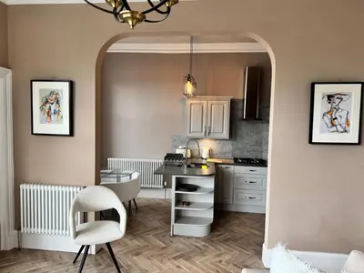 a kitchen with a table and a chair in a room at Largs Sandringham Apartment in Largs