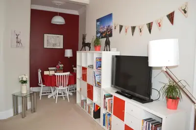 a living room with a television and a dining room at Hamish's Hame Edinburgh Licence No EH 69774 R Energy Rating C in Edinburgh
