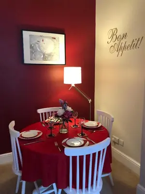 a red dining room table with a red tablecloth and white chairs at Hamish's Hame Edinburgh Licence No EH 69774 R Energy Rating C in Edinburgh