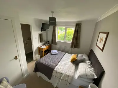 a small bedroom with a bed and a window at Stables Guest House in Newton Stewart