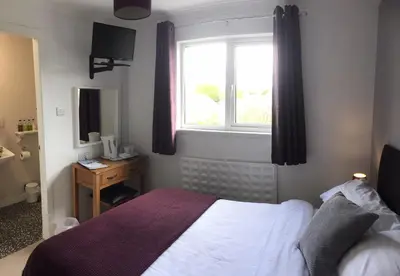 a bedroom with a bed and a window at Stables Guest House in Newton Stewart