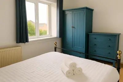 a bedroom with a bed with two towels on it at Cozy 2BR Flat Near City Centre Free Parking Fast Wifi in Edinburgh