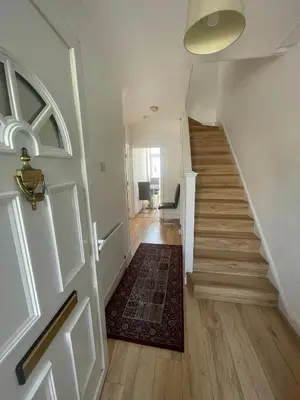 a hallway with a door and a staircase with a rug at Large room with bathroom in Moffat
